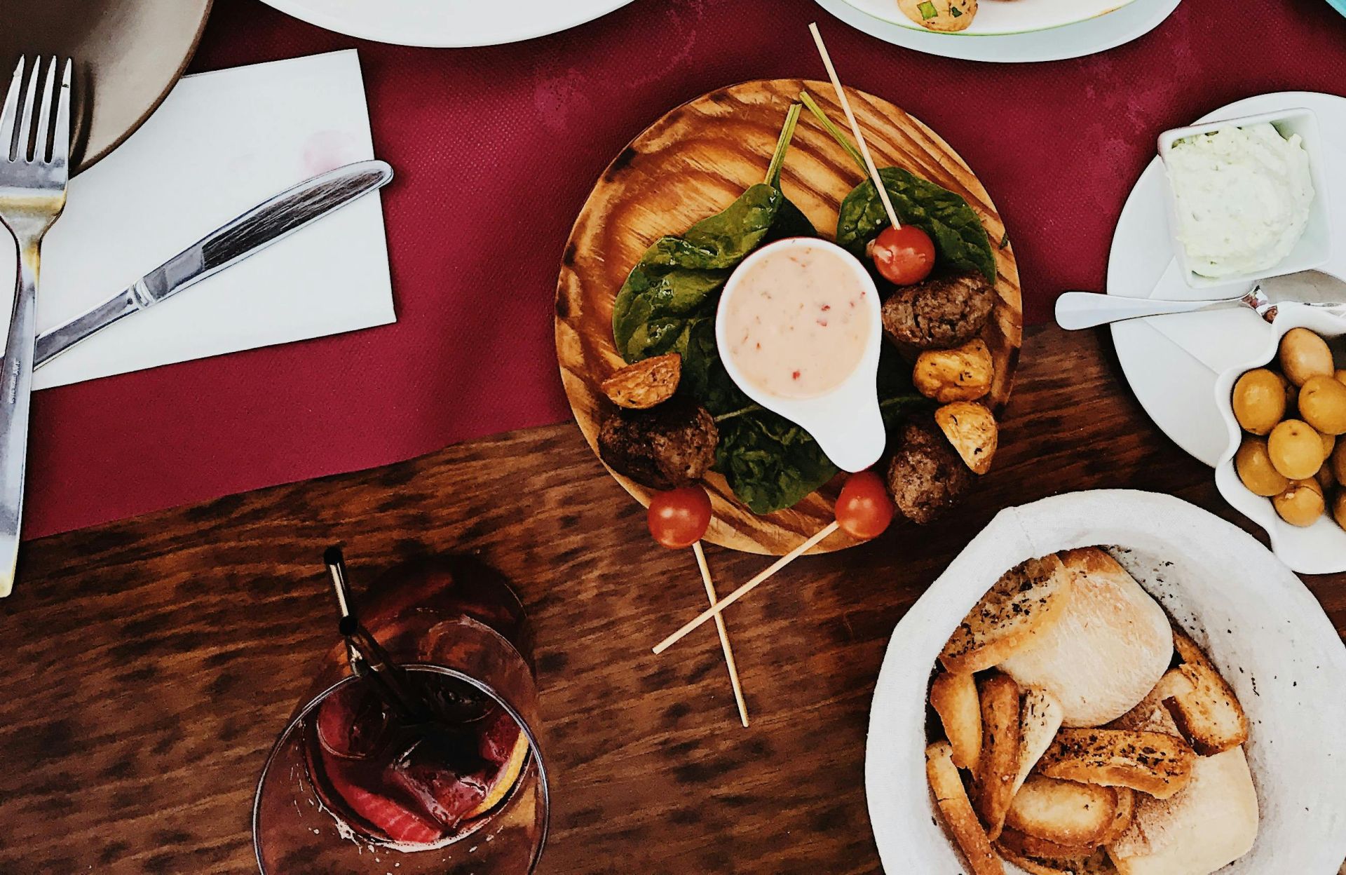 A colorful spread of gourmet dishes on a classy dinner table setting.