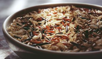 Macro shot of a ceramic bowl filled with colorful mixed wild rice, highlighting textures.