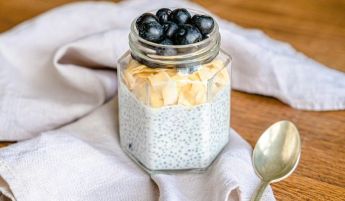 Delicious chia pudding topped with blueberries and almond flakes in a jar.